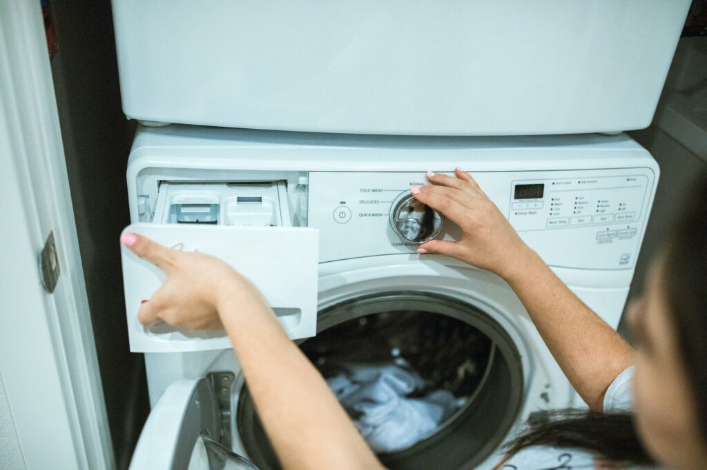 a person holding white front load washing machine